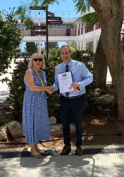 Jean Passmore presenting Christos with the Exams Officer of the Year 2023 award 